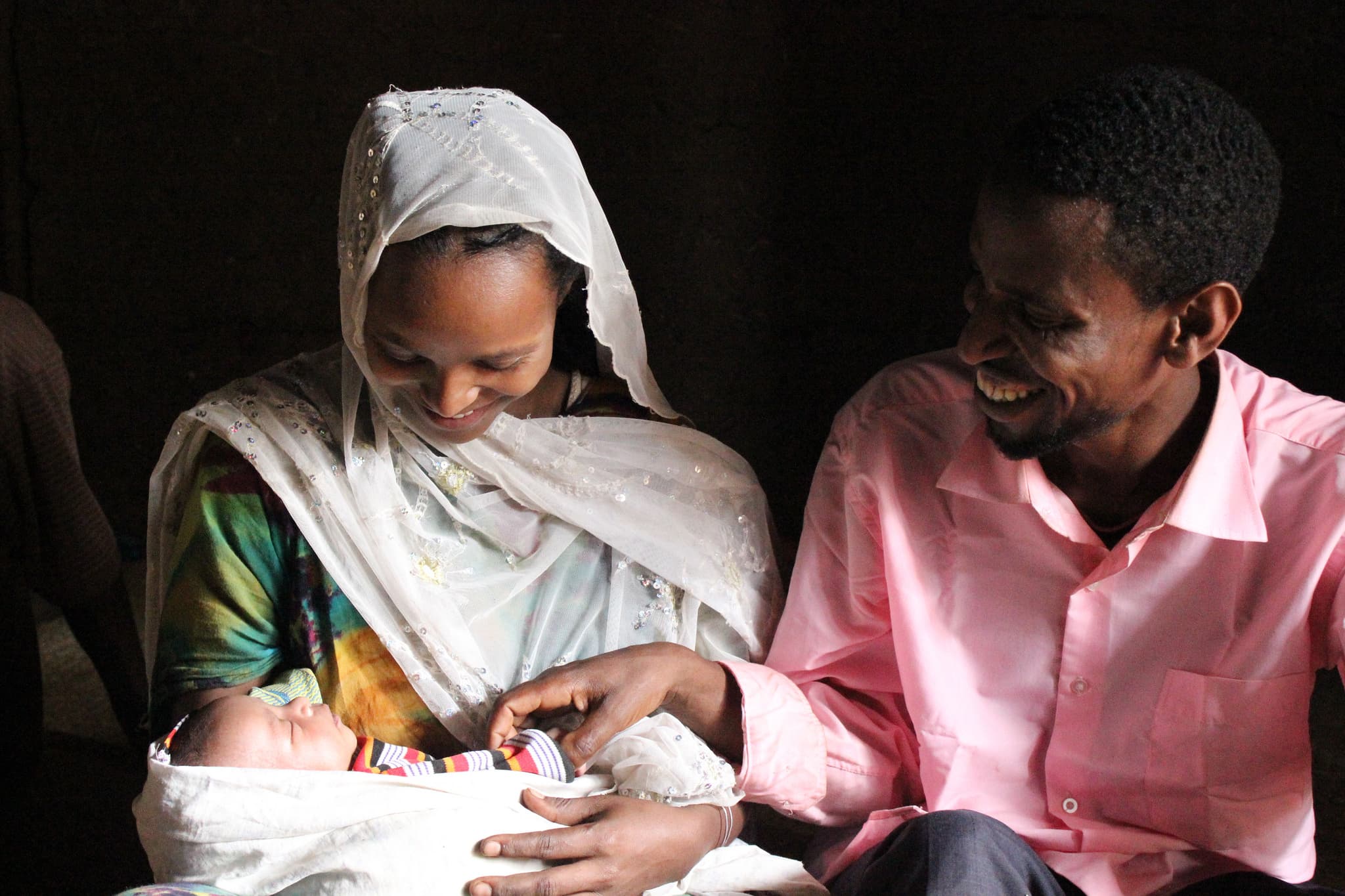African mother and family embracing healthy newborn infant in postpartum recovery